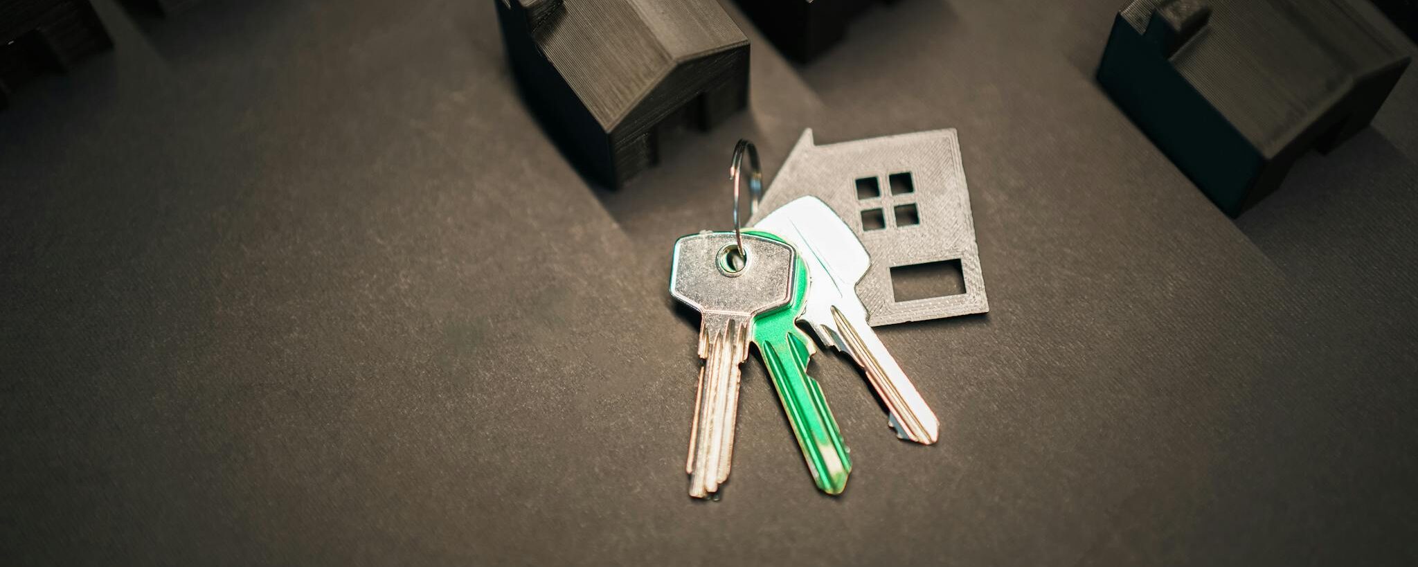 Miniature house models and keys symbolize real estate investment and housing market.
